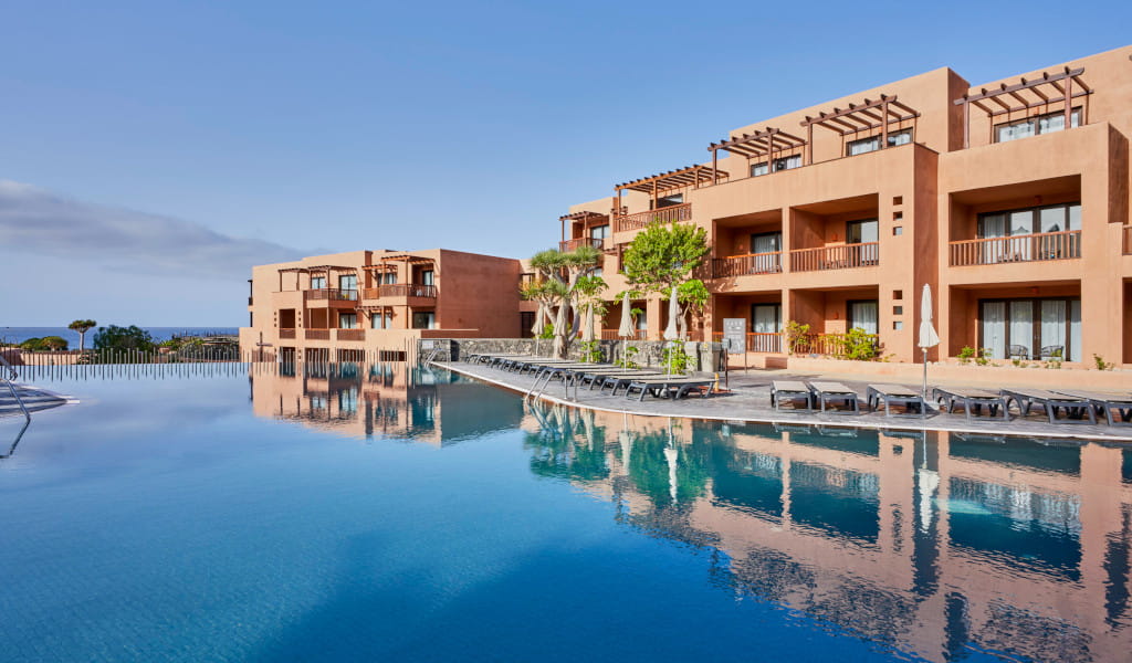 Piscina e edificio alberghiero a Tenerife con vista sul mare.