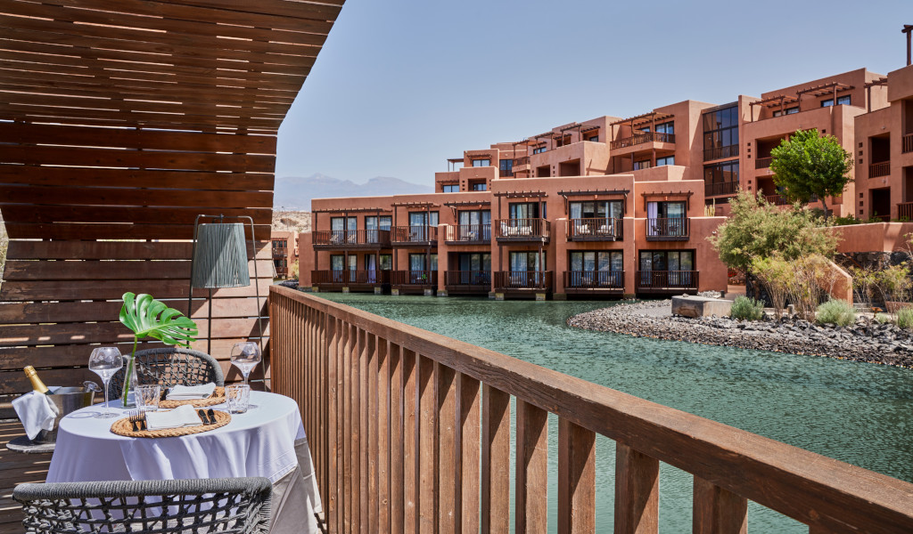 Terrazza con tavolo e sedie accanto a un canale d'acqua in un complesso turistico a Tenerife.