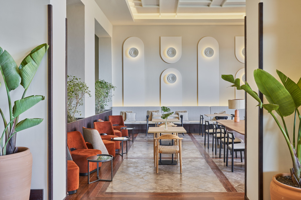 Stanza con poltrone e tavoli in un hotel a Tenerife, decorata con piante e pannelli da parete.