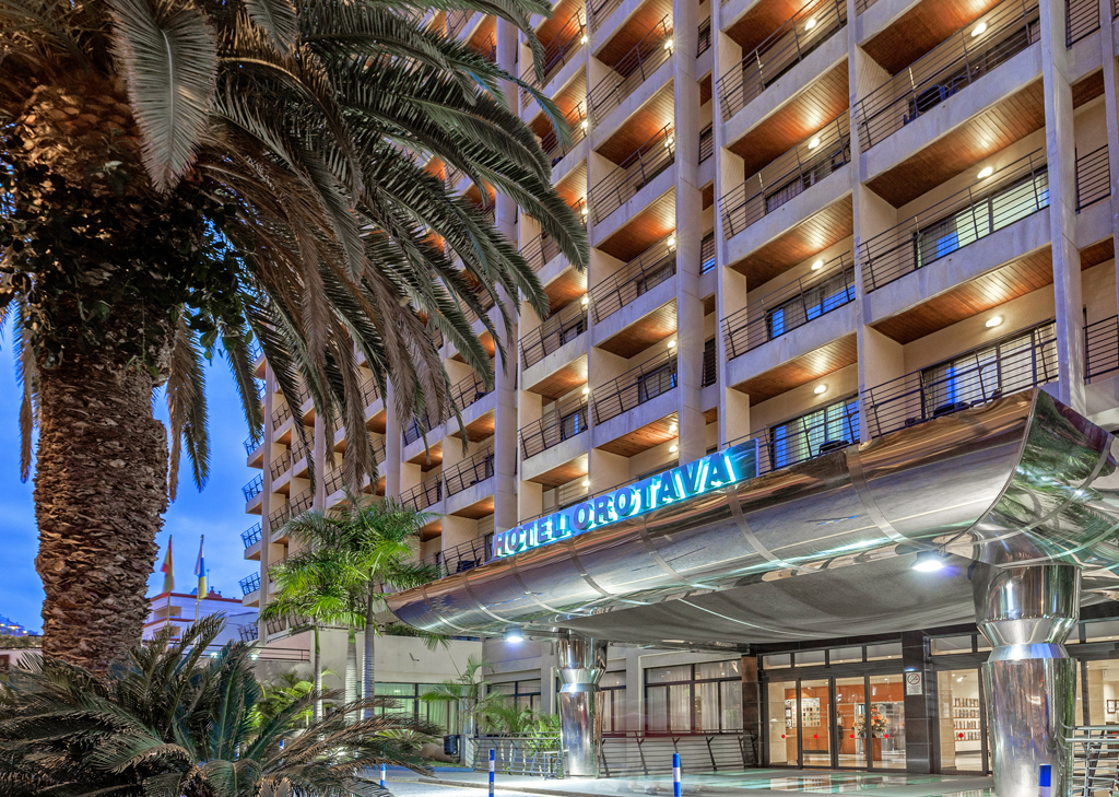 Edificio dell'Hotel Orotava a Tenerife, visto di fronte con palme intorno.