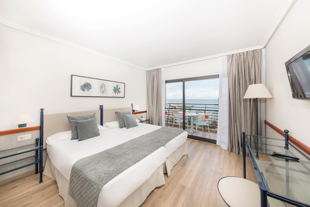 Camera d'albergo con due letti, balcone e vista mare a Tenerife.