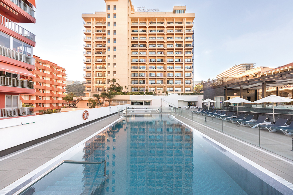 Piscina dell'hotel con edificio alto a Puerto de la Cruz, Tenerife.