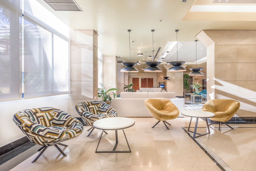 Lobby di un hotel a Tenerife con poltrone colorate e tavolini.