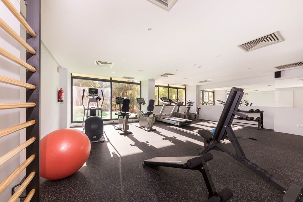 Palestra con attrezzature moderne a Tenerife, inclusi pesi e tapis roulant.