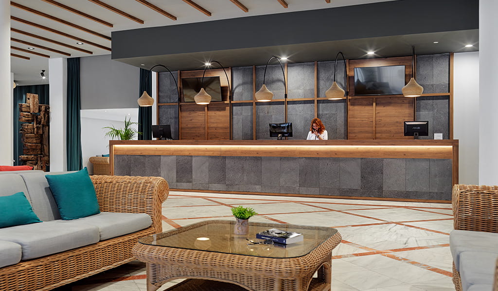 Reception di un hotel a Tenerife con arredamento moderno e receptionist.