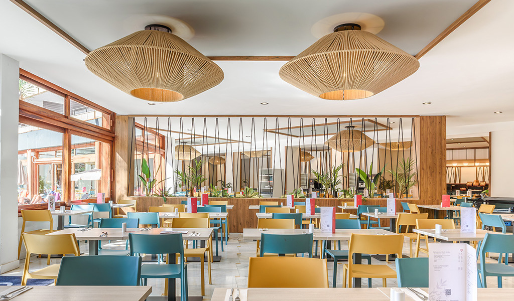 Ristorante con sedie colorate e lampade a Tenerife sullo sfondo.