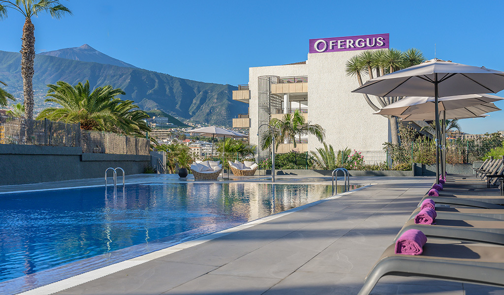 Piscina all'aperto con vista sul Monte Teide a Tenerife, hotel Fergus sullo sfondo.