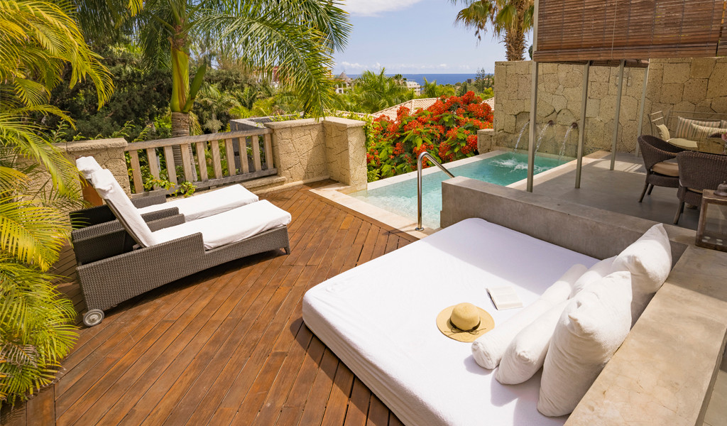 Terrazza con lettini, piscina e vegetazione a Tenerife.