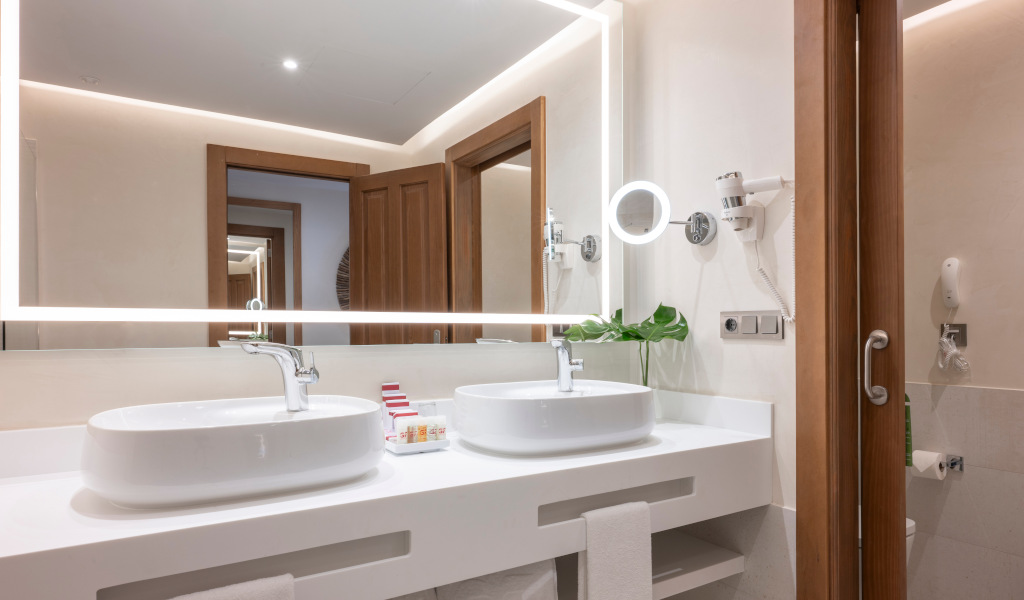 Bagno moderno con doppio lavabo, specchio illuminato e articoli da toeletta a Tenerife.