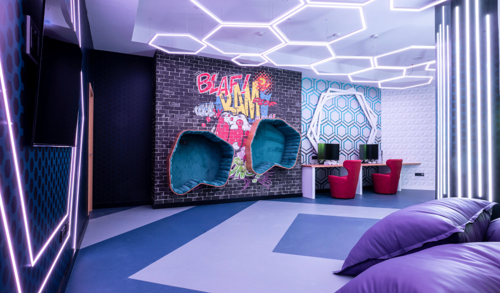 Sala giochi con graffiti BLAM! su muro e luci LED esagonali a Tenerife.