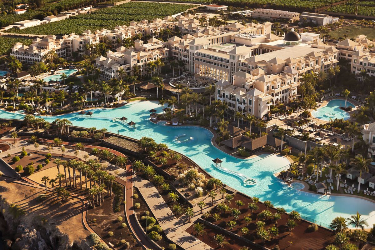 Complesso alberghiero con piscine e palme a Tenerife, visto dall’alto.