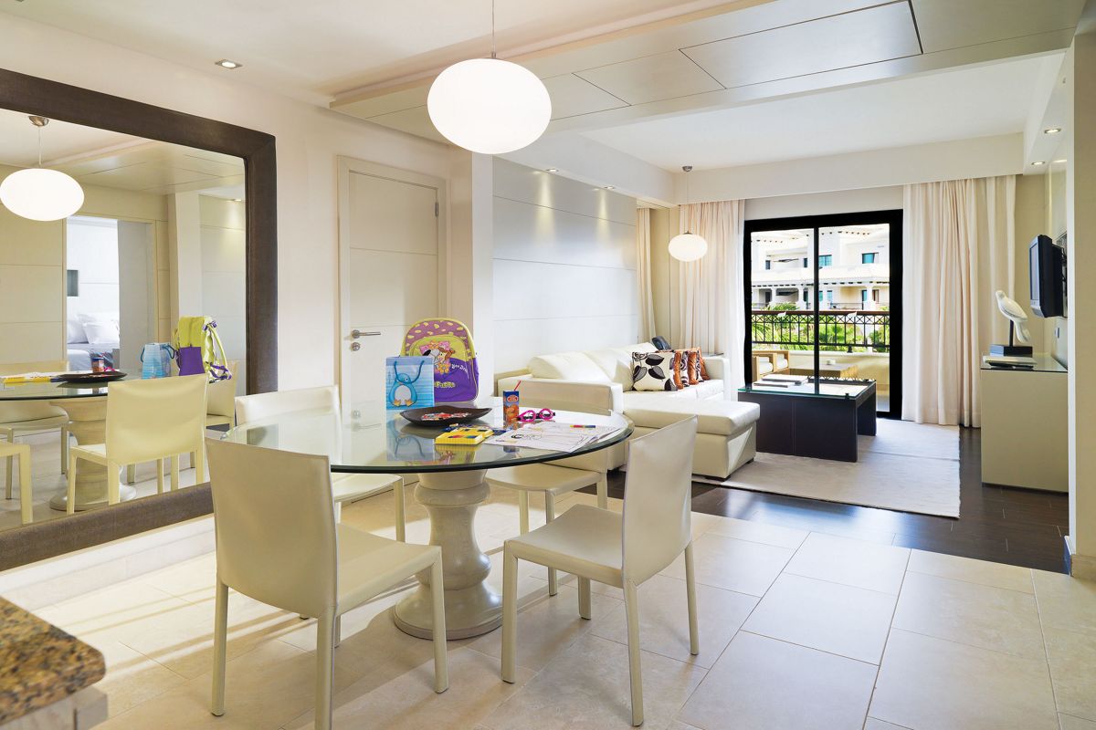 Interno moderno con tavolo, sedie e divano bianco vicino alla finestra a Tenerife.