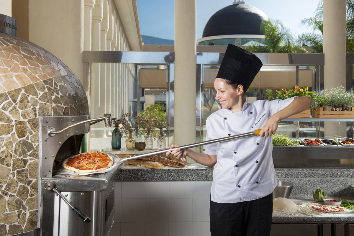 Chef mentre inforna una pizza nel ristorante all'aperto nel sud di Tenerife.