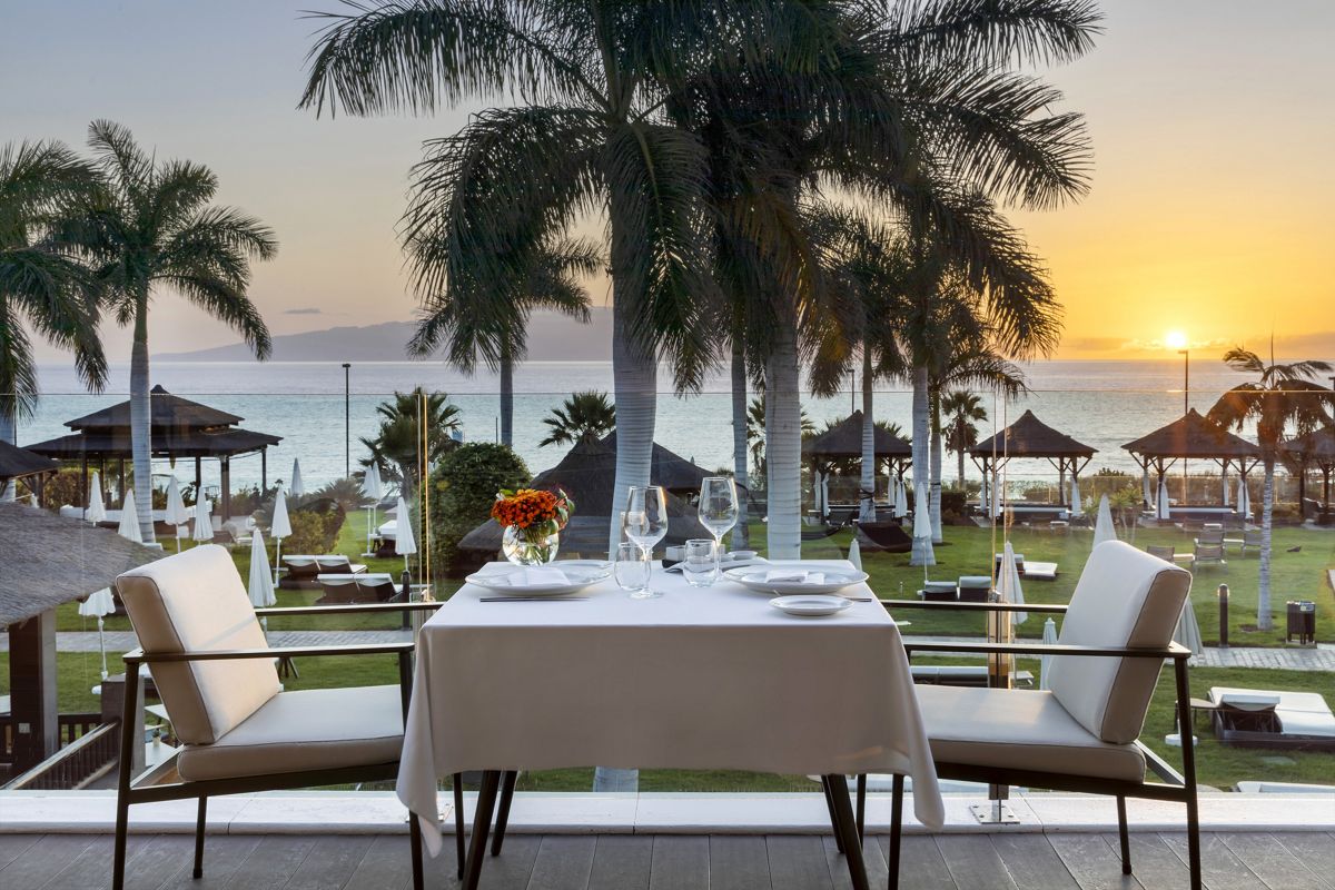 Tavolo apparecchiato con vista mare al tramonto a Tenerife.