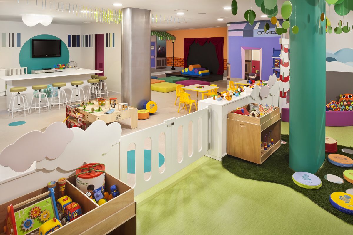 Area giochi per bambini con tavoli, sedie, giocattoli e pareti colorate a Tenerife.
