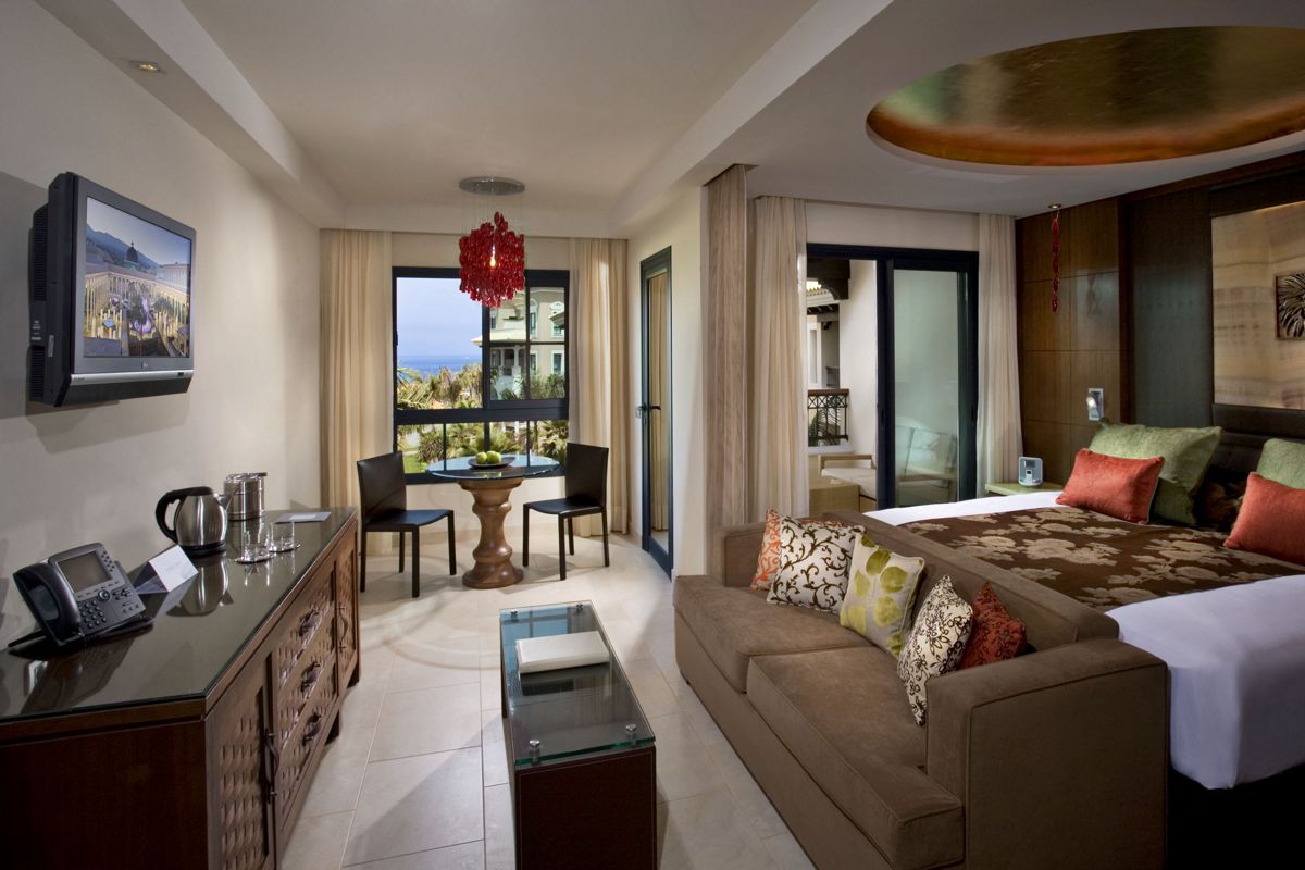 Suite moderna con vista mare a Tenerife, tavolo con sedie e divano.