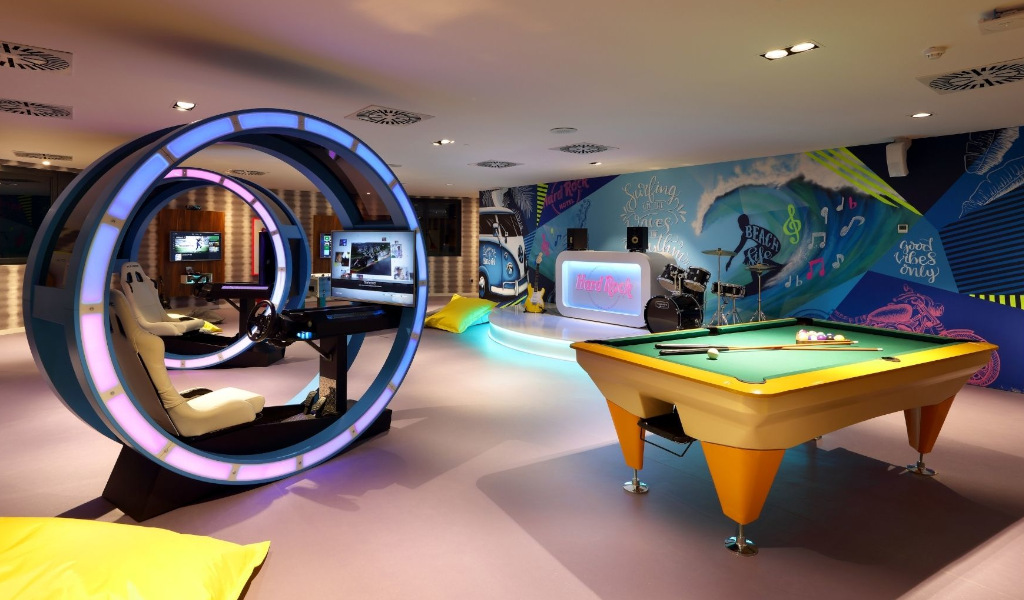 Sala giochi con tavolo da biliardo, simulatore di guida e batteria al Hard Rock Tenerife.