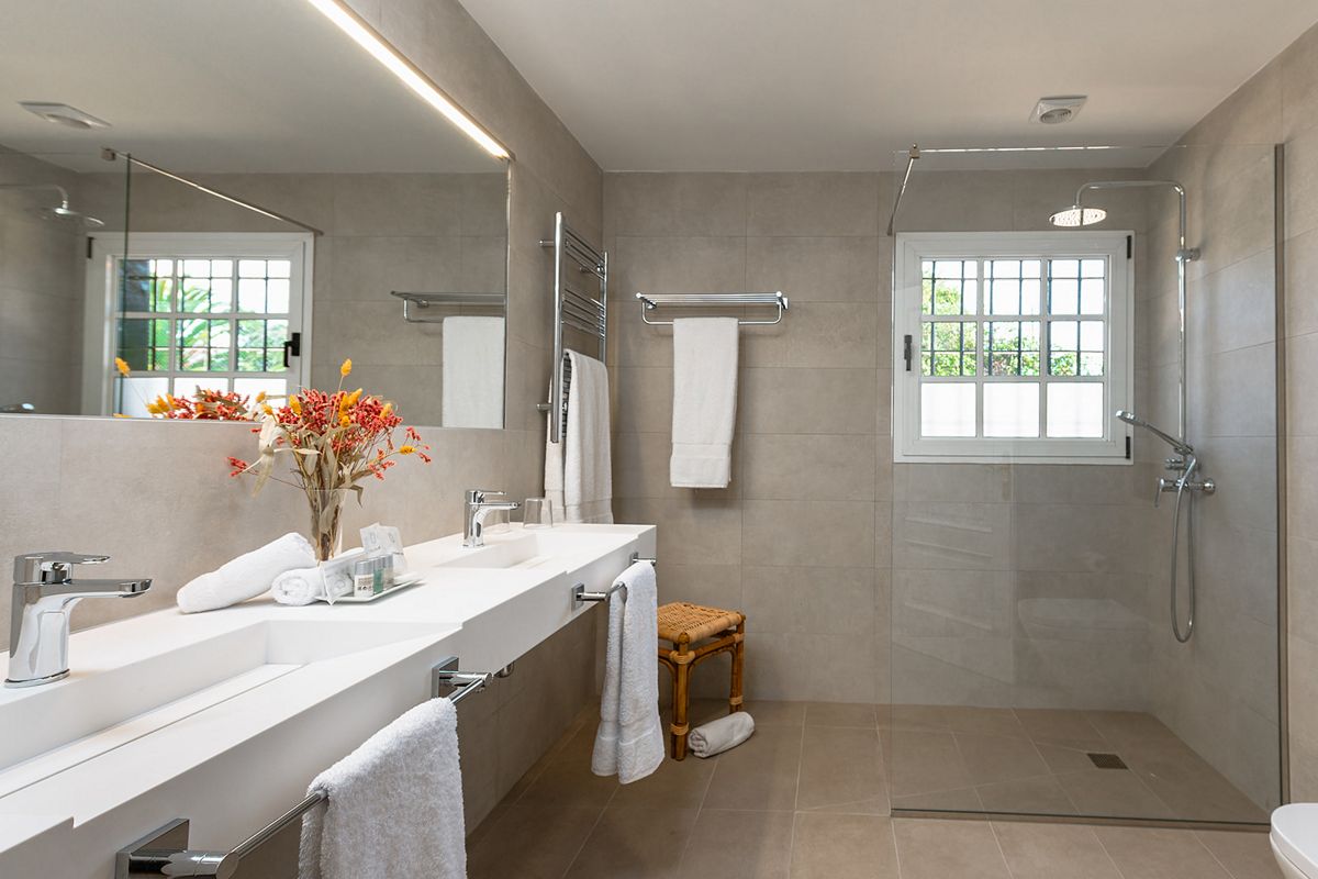 Bagno moderno con doccia, lavabo doppio e asciugamani a Puerto de la Cruz, Tenerife.