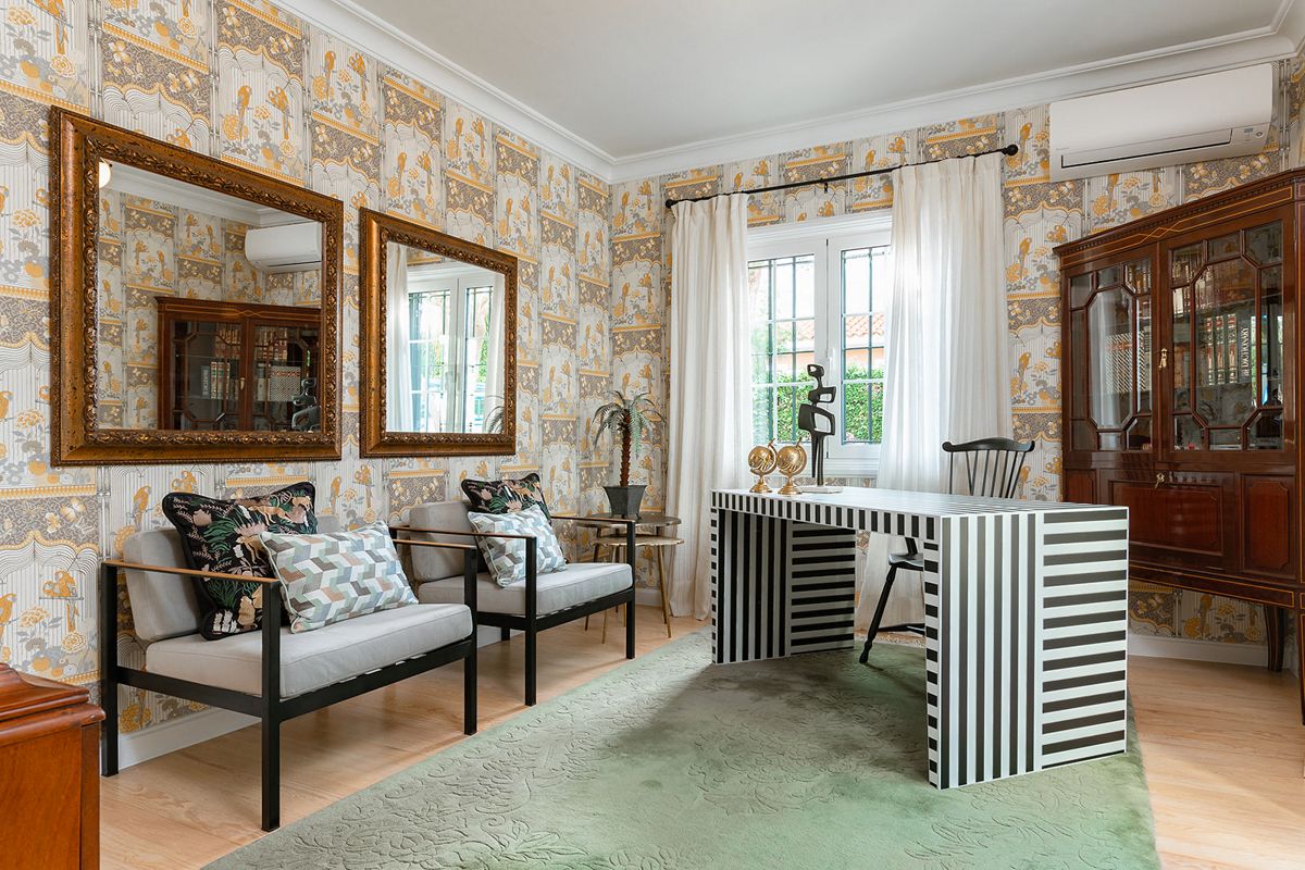 Sala con scrivania a righe e sedie, specchi, finestra e decorazioni a Santa Cruz de Tenerife.