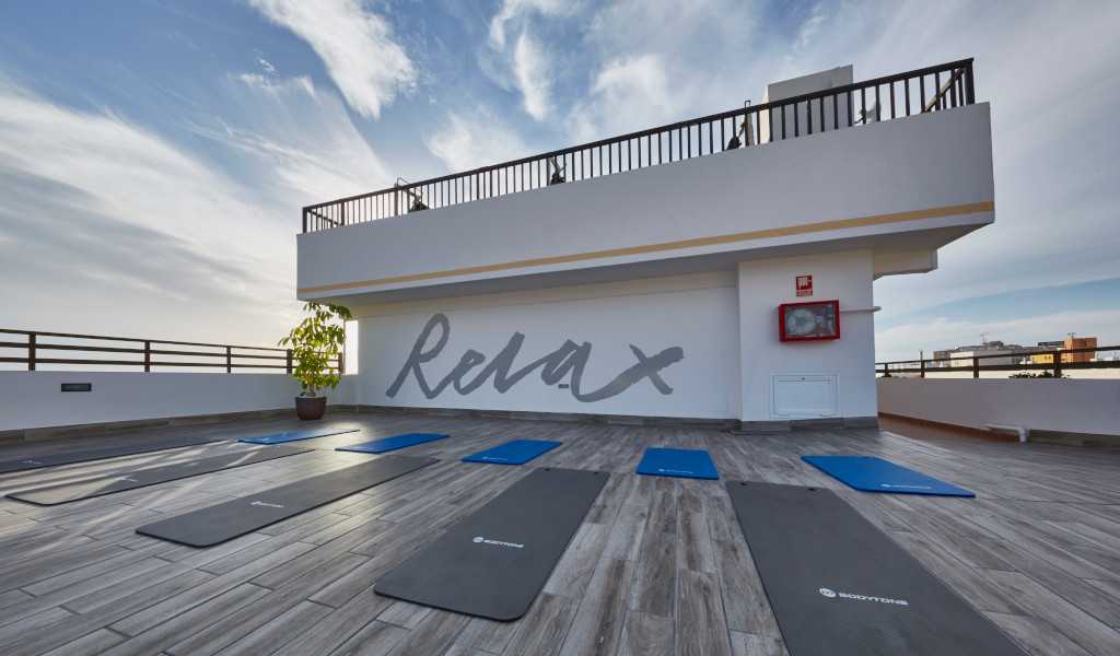 Tappetini da yoga su terrazza con scritta Relax sul muro a Tenerife.