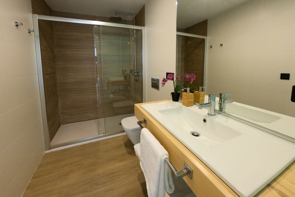 Bagno moderno con cabina doccia, lavabo bianco e asciugamano a Tenerife.