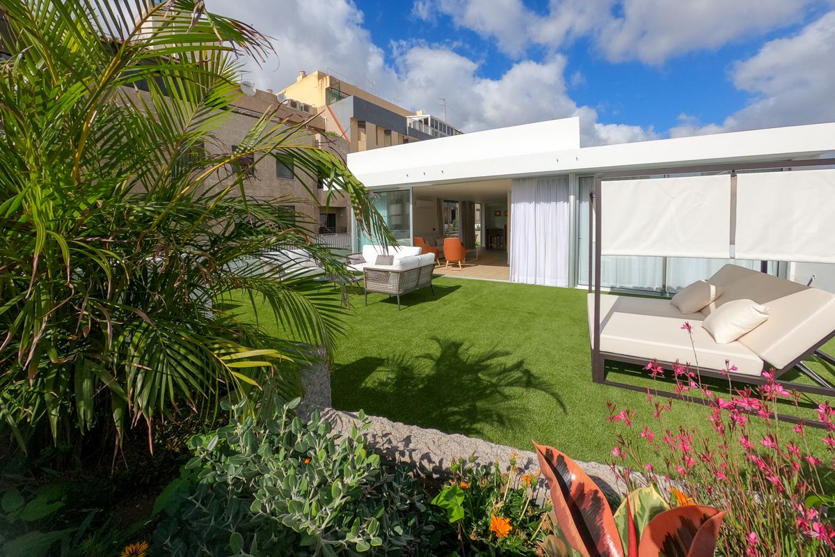 Terrazza con prato verde e mobili, edificio sullo sfondo a Tenerife.