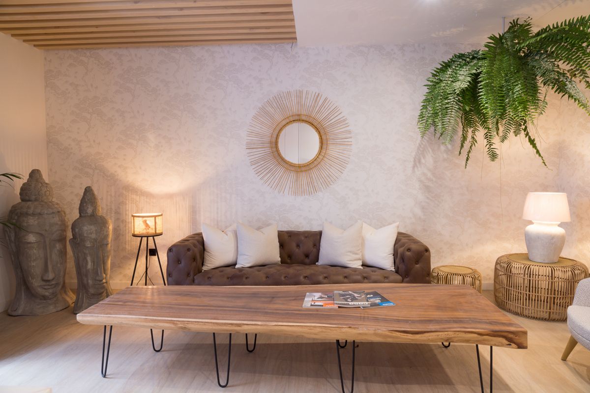 Salotto con divano marrone, tavolino in legno e specchio rotondo decorativo a Tenerife.