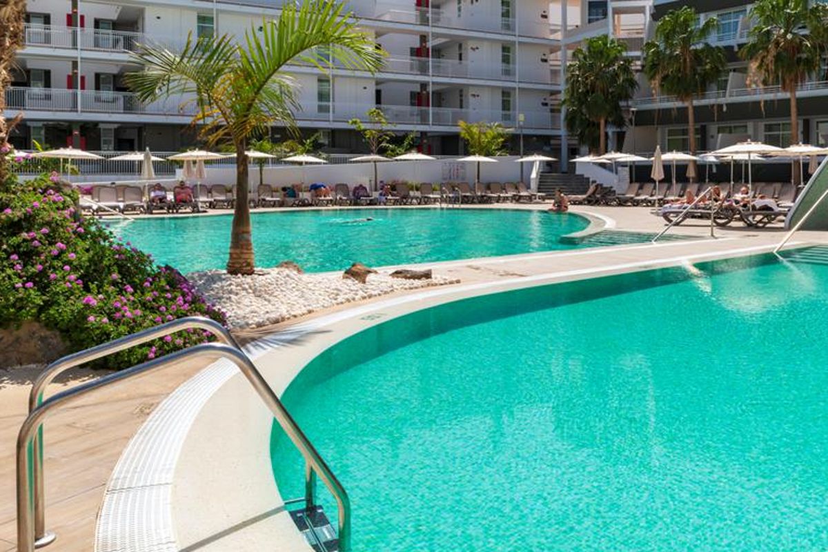 Piscina all'aperto con sedie a sdraio e ombrelloni a Tenerife.