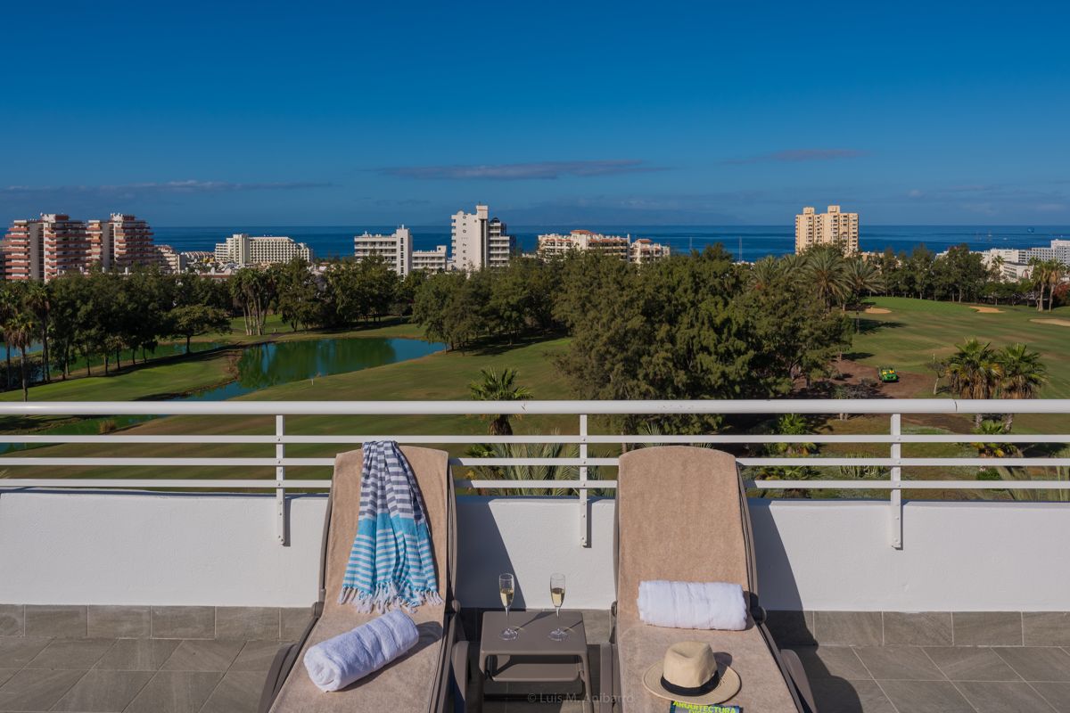 Lettini su terrazza con vista sul campo da golf e mare a Tenerife.