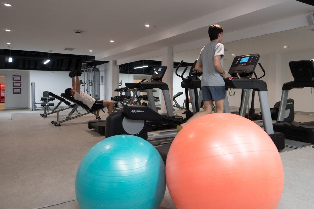 Palestra a Tenerife con persone su tapis roulant e palle da ginnastica.