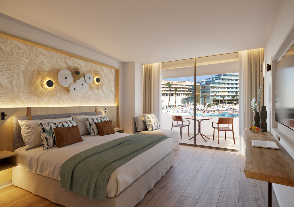 Camera d'hotel con letto matrimoniale e balcone con vista sulla piscina a Tenerife.