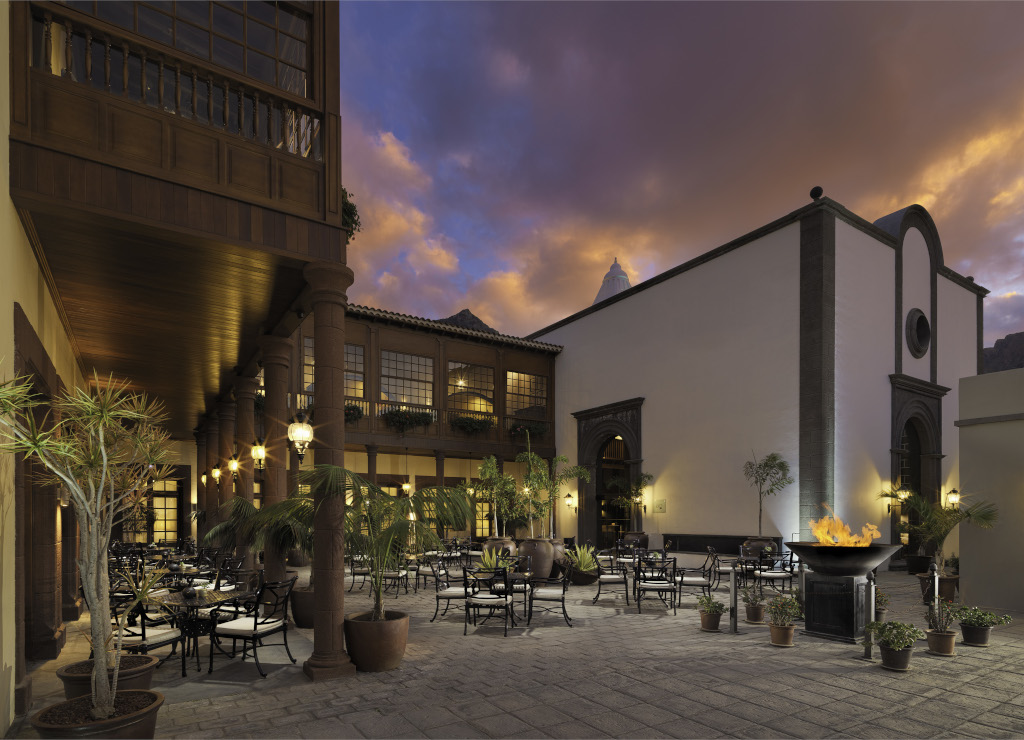 Cortile del ristorante al tramonto a Tenerife, tavoli circondati da piante.