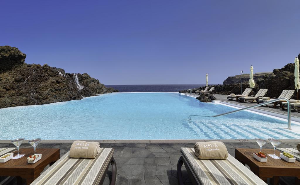 Piscina a sfioro con vista mare a Tenerife, sdraio e asciugamani MELIÁ.