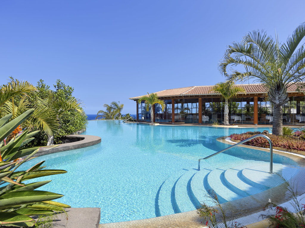 Piscina tropical con palme e vista sull'oceano a Tenerife.