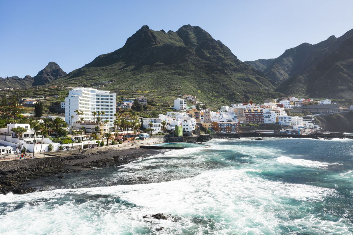 Costa di San Andrés a Tenerife con montagne e edifici sullo sfondo.
