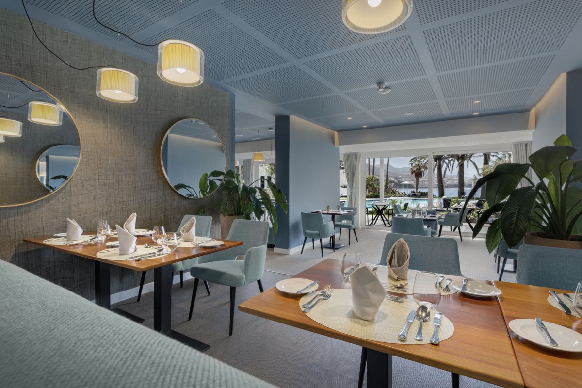 Ristorante elegante con tavoli apparecchiati e vista piscina a Tenerife.