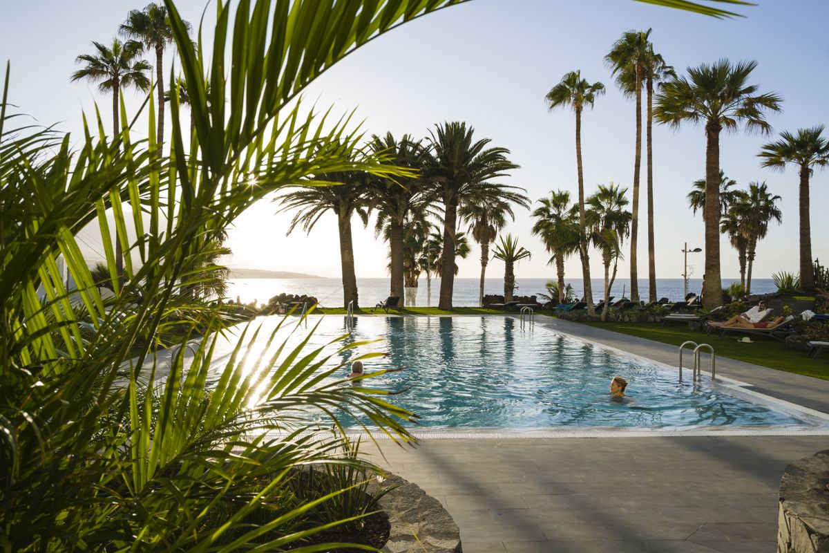 Piscina con palme al tramonto a Santa Cruz de Tenerife.