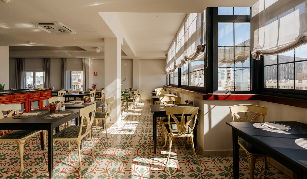 Ristorante luminoso con sedie e tavoli in legno a Tenerife.