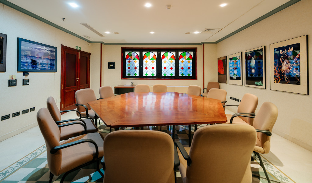 Sala riunioni con tavolo ovale e sedie, finestra colorata e quadri alle pareti, Tenerife.
