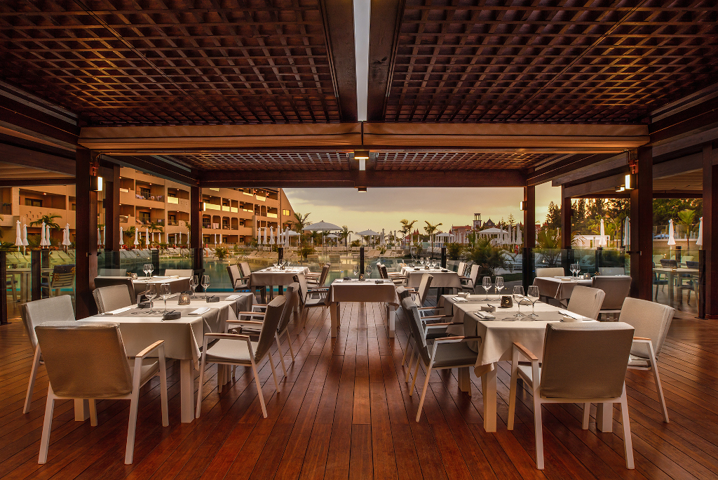 Terrazza del ristorante all'aperto a Guia de Isora, con tavoli apparecchiati.