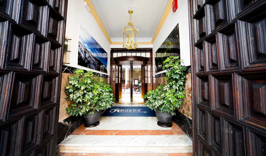 Ingresso principale dell'Hotel Adonis Plaza a Tenerife con piante e decorazioni.