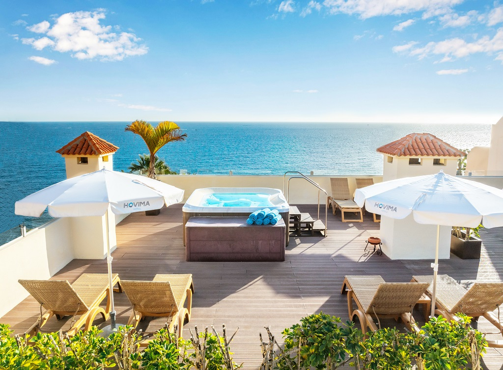 Terrazza con sedie a sdraio, ombrelloni Hovima e jacuzzi vista mare a Tenerife.