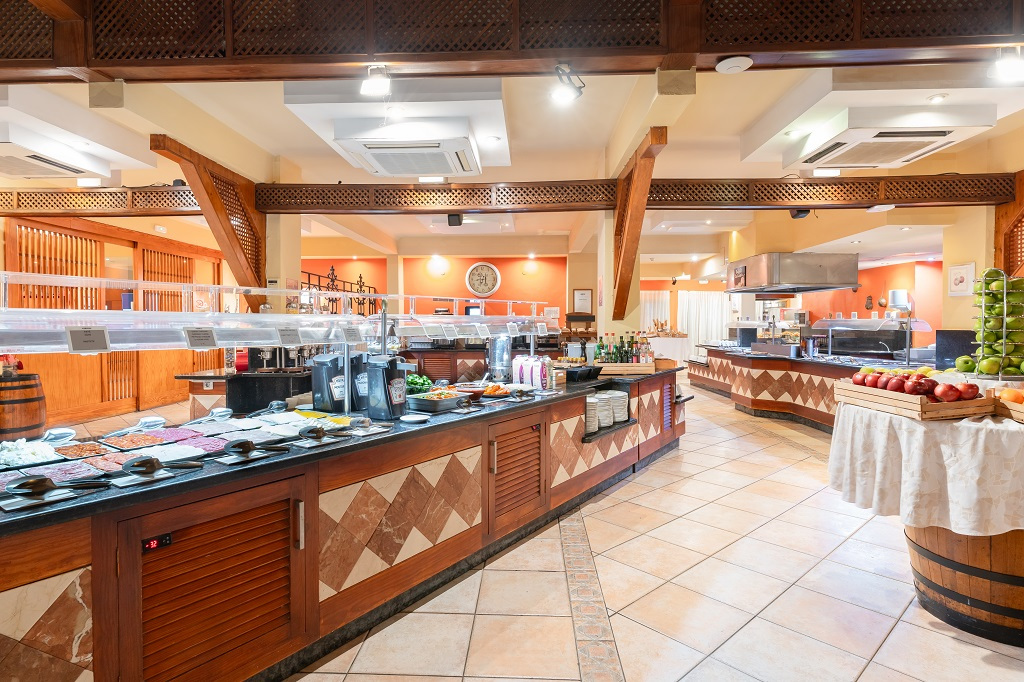 Buffet di un ristorante a Tenerife con piatti e frutta esposti su tavoli.