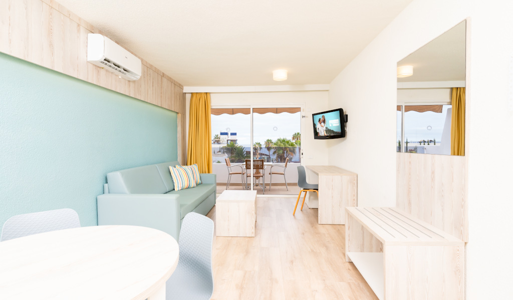 Soggiorno moderno con divano, tavolo, TV e balcone a Tenerife.