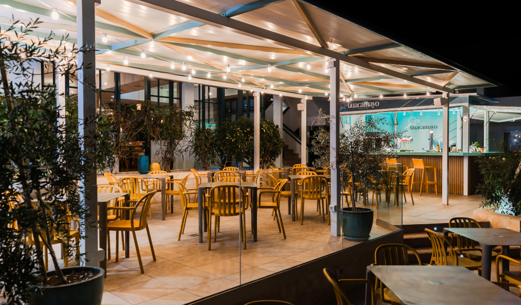Terrazza del ristorante Guacamayo a Tenerife con tavoli e sedie gialle.