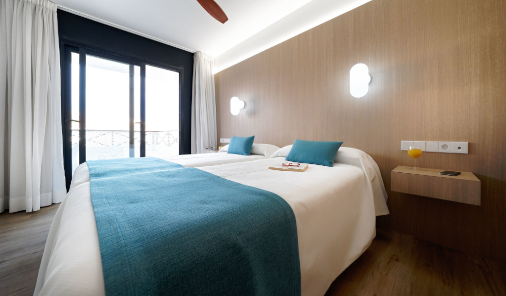 Camera da letto moderna con due letti singoli e balcone a Tenerife.