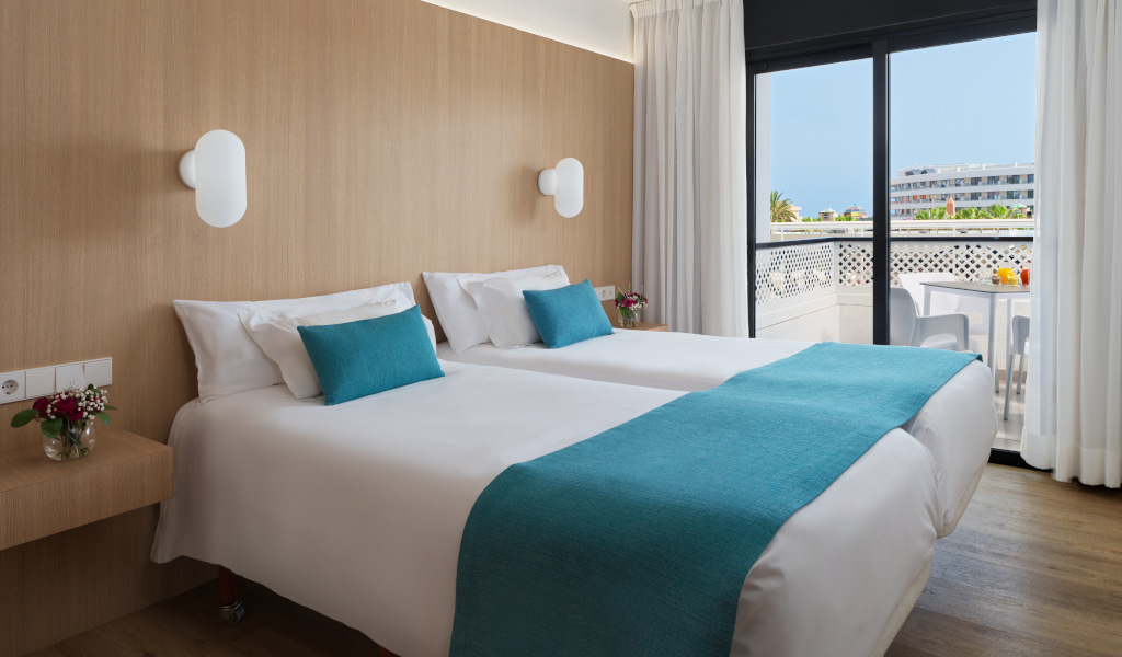 Camera d'albergo a Tenerife con due letti singoli e balcone esterno.