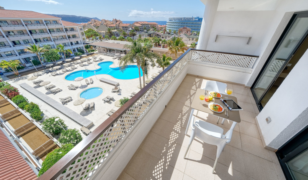 Balcone con tavolo apparecchiato e vista sulla piscina a Tenerife.