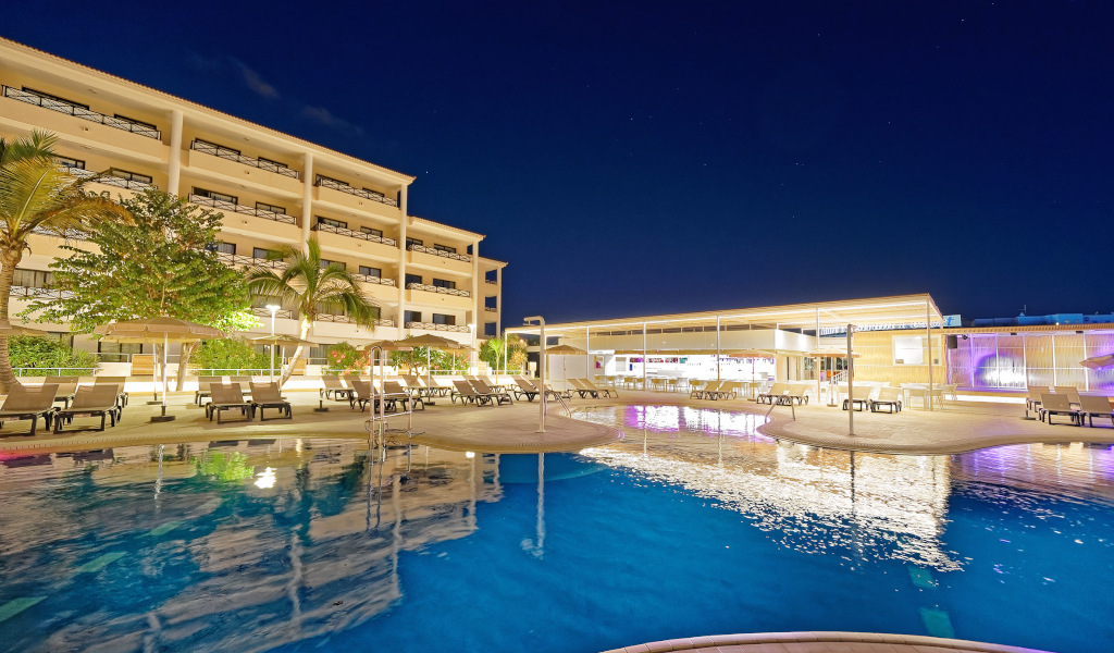 Hotel di Tenerife con piscina illuminata di notte.