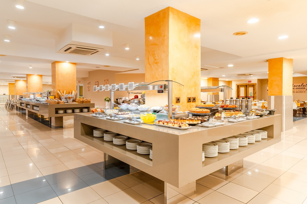 Buffet di un ristorante a Tenerife con piatti e posate disposti su tavoli moderni.